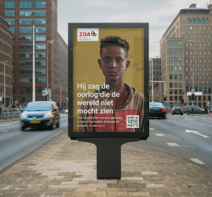 Een staande reclamezuil in een drukke stadsomgeving. Op de poster staat een portret van een jong persoon die recht in de camera kijkt. Bovenin de hoek staat het logo van de hulporganisatie ZOA. Over de foto is in witte letters de tekst "Hij zag de oorlog die de wereld niet mocht zien" geplaatst. Daaronder staat een kleinere oproep tot donatie met een QR-code. 
